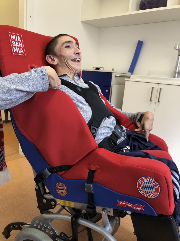 Michael Aigner sitzt in einer Rollstuhl-Sitzschale im FC Bayern Design