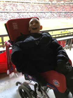 Michael Aigner besucht in seinem FC Bayern Rollstuhl ein Spiel in der Allianz Arena