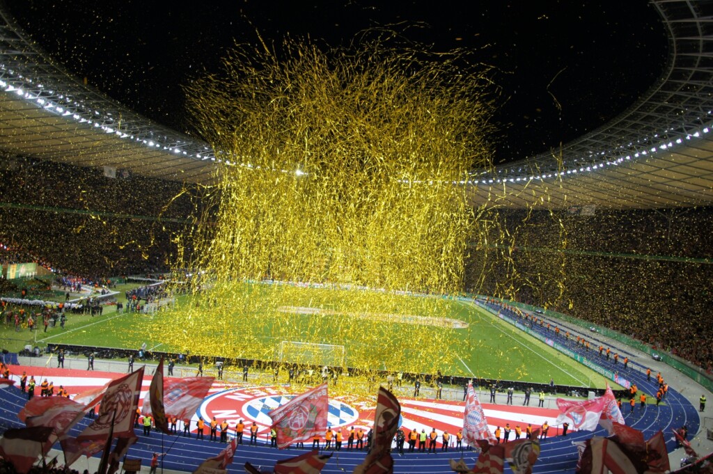 Goldenes Lametta und viele Bayern-Fahnen in der Kurve mit Blick aufs Spielfeld