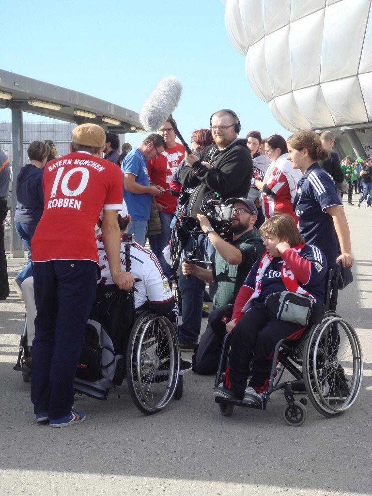 Uli und Elisabeth werden vor der Allianz-Arena von einem Kamerateam interviewt