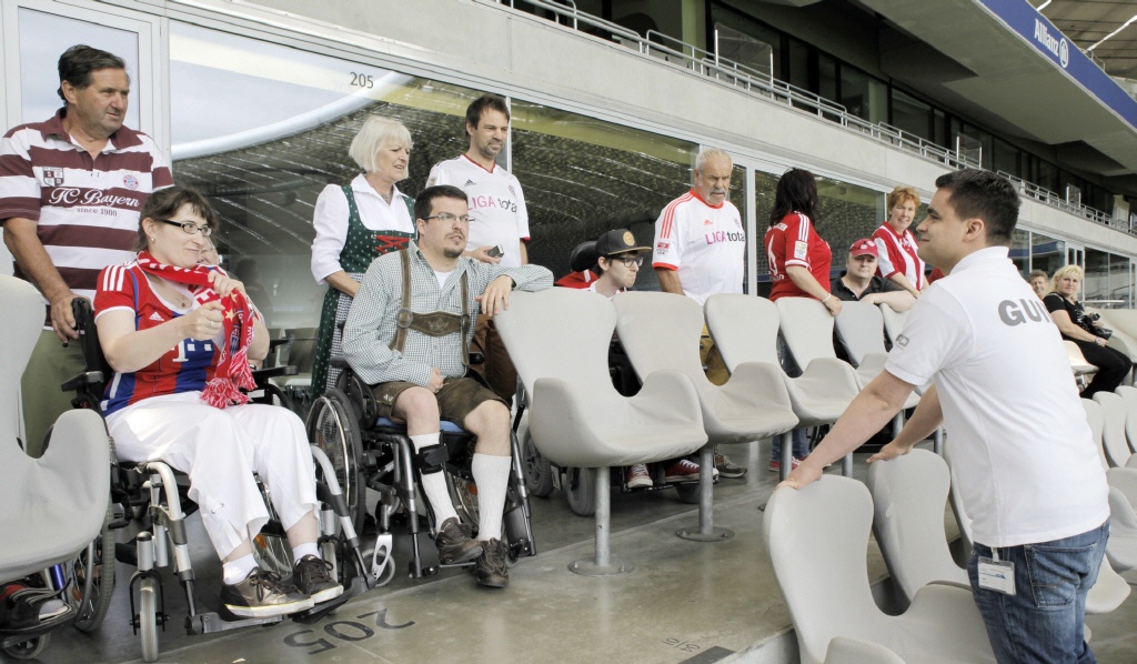 Ein Mann steht vor einer Gruppe auf der Tribüne