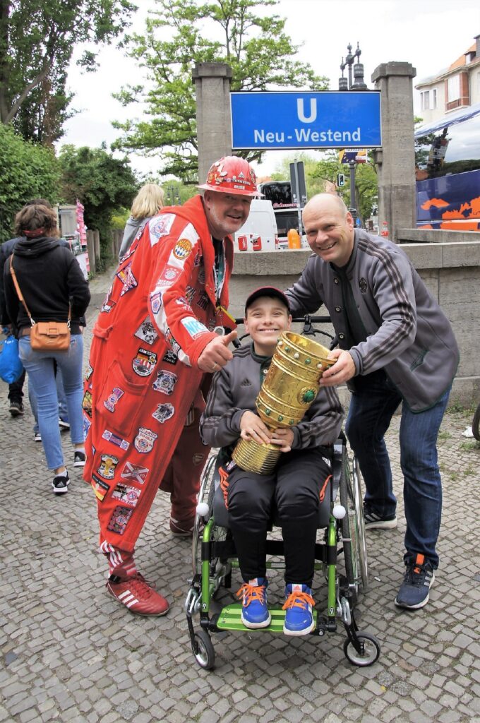 Rollwagerl-Mitglied Maximilian Böhme mit Pokal und sein Vater Kai Zeumer vor der U-Bahn-Station Neu-Westend