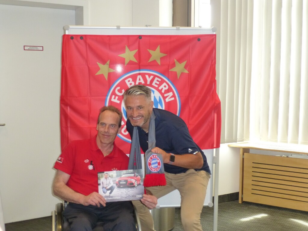 Gerd Schönfelder und ein Bayern Fan im Rollstuhl posieren für ein Foto