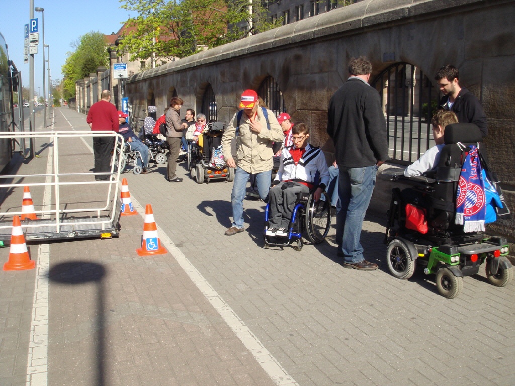 Einige Rollifahrer*innen und Fußgänger*innen vor dem Memorium der Nürnberger Prozesse