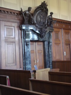 Eingangstür zum Gerichtssaal mit steinernem Rahmen, Büste und Figuren