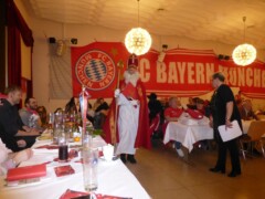 Nikolaus im Saal, im Hintergrund ein großes FC Bayern Banner