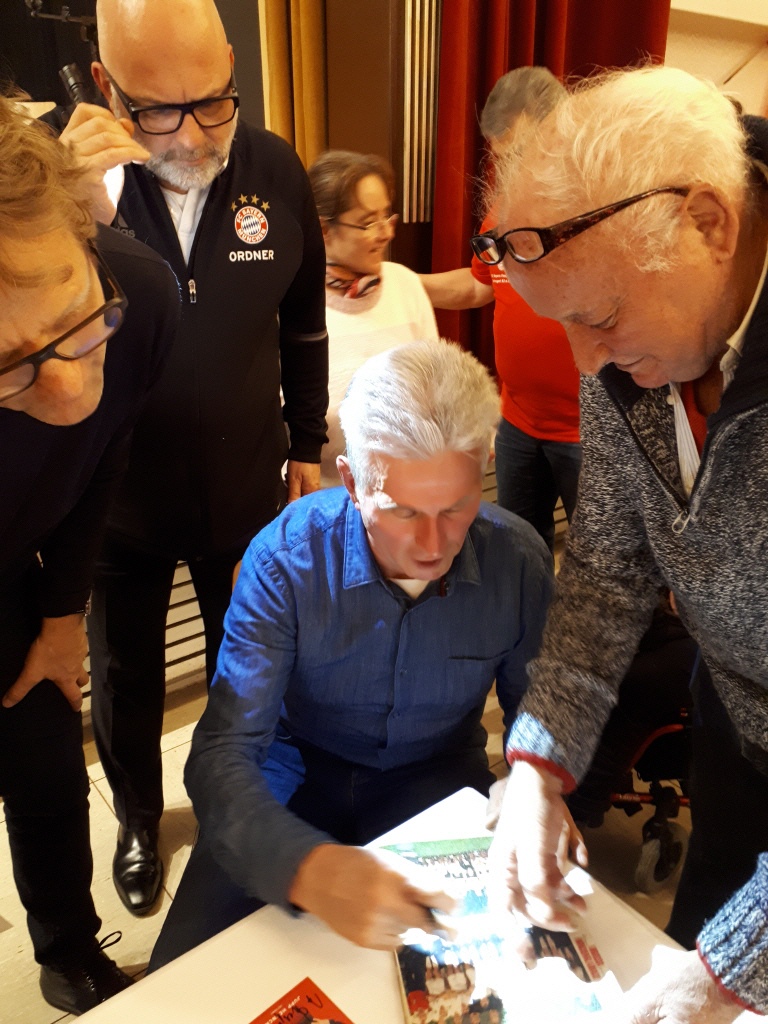 Norbert und Jupp Heynckes schauen sich gemeinsam ein Buch an