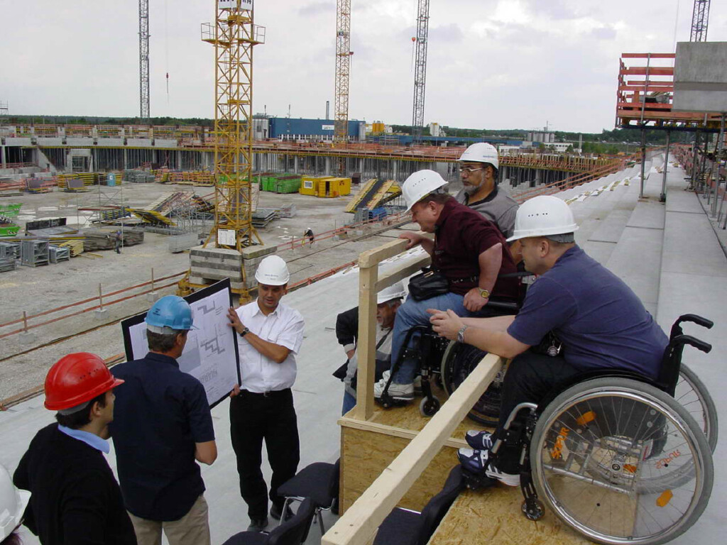 Menschen mit und ohne Rollstuhl auf einer Baustelle