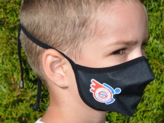 Kind mit Mund-Nasenschutz mit Rollwagerl-Logo in schwarz