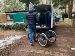 Mann beginnt ein E-Dreirad in einen Kleinbus zu verladen