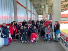 Ein Gruppenfoto im Stadion von Menschen mit und ohne Rollstuhl.