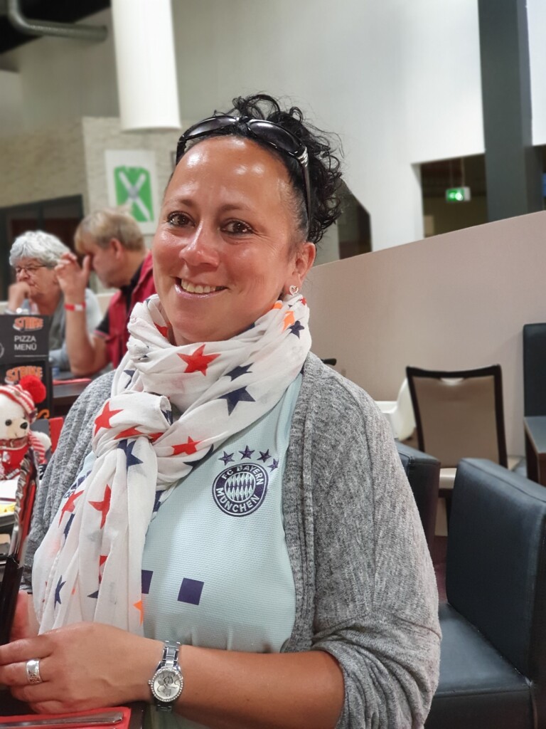 Eine Frau im Bayern München Trikot lachend (1)