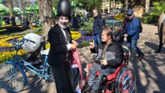 Charlie Chaplin und ein Rollstuhlfahrer in einen Park.