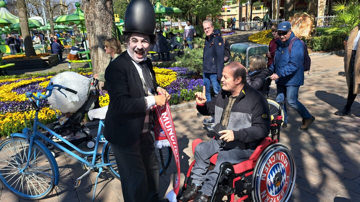 Charlie Chaplin und ein Rollstuhlfahrer in einen Park.