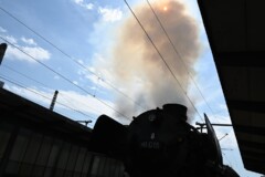 Eine Dampflok im Bahnhof. Dampf steigt aus der Lok.
